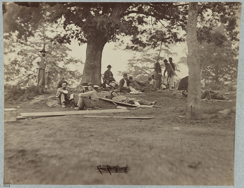 Wounded soldiers resting outdoors at a hospital in Fredericksburg, Virginia; photographed between 1861 and 1865.